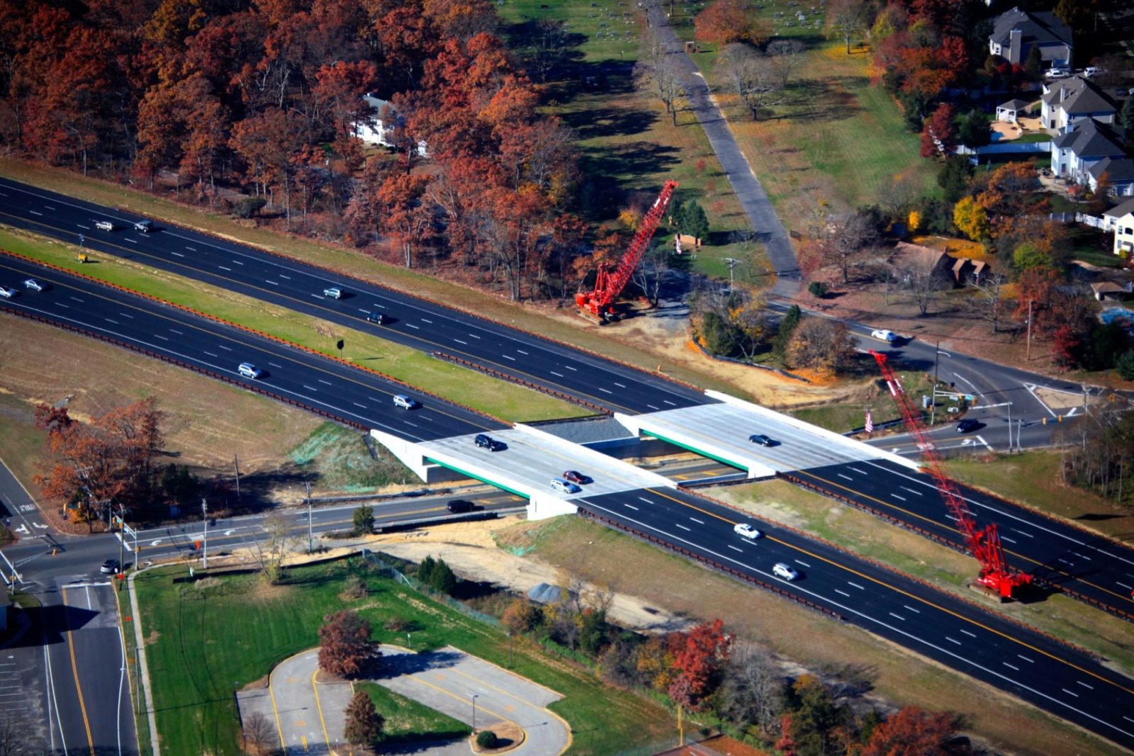 Highway lined with colorful orange, red, and green trees