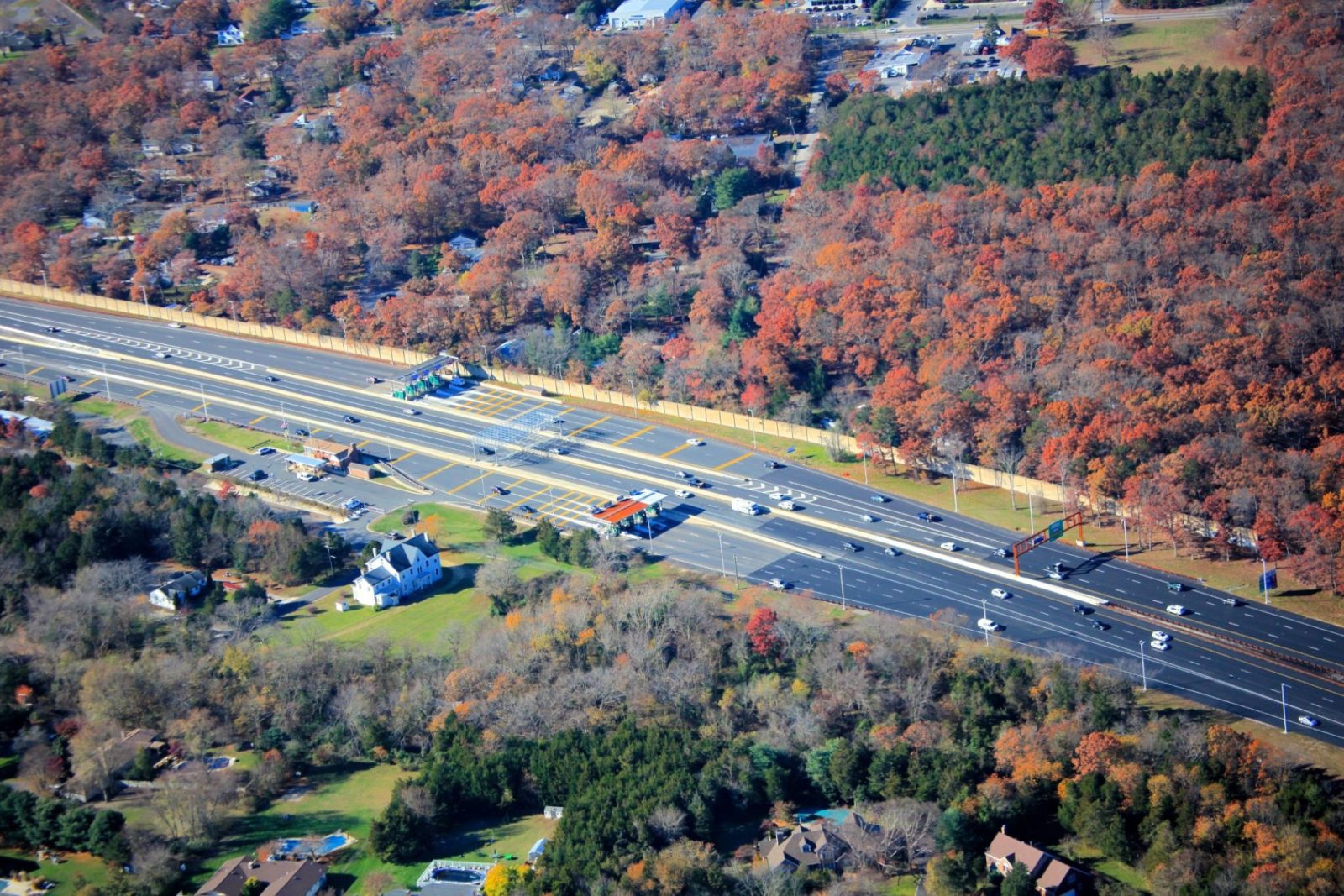 Highway lined with colorful orange, red, and green trees