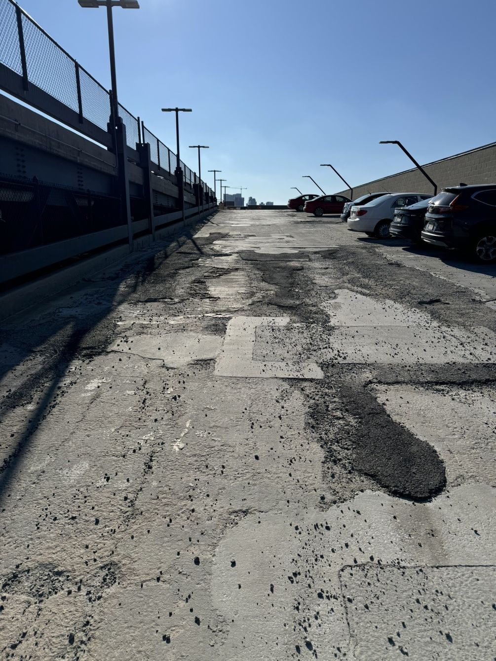 Exterior parking garage with large potholes.