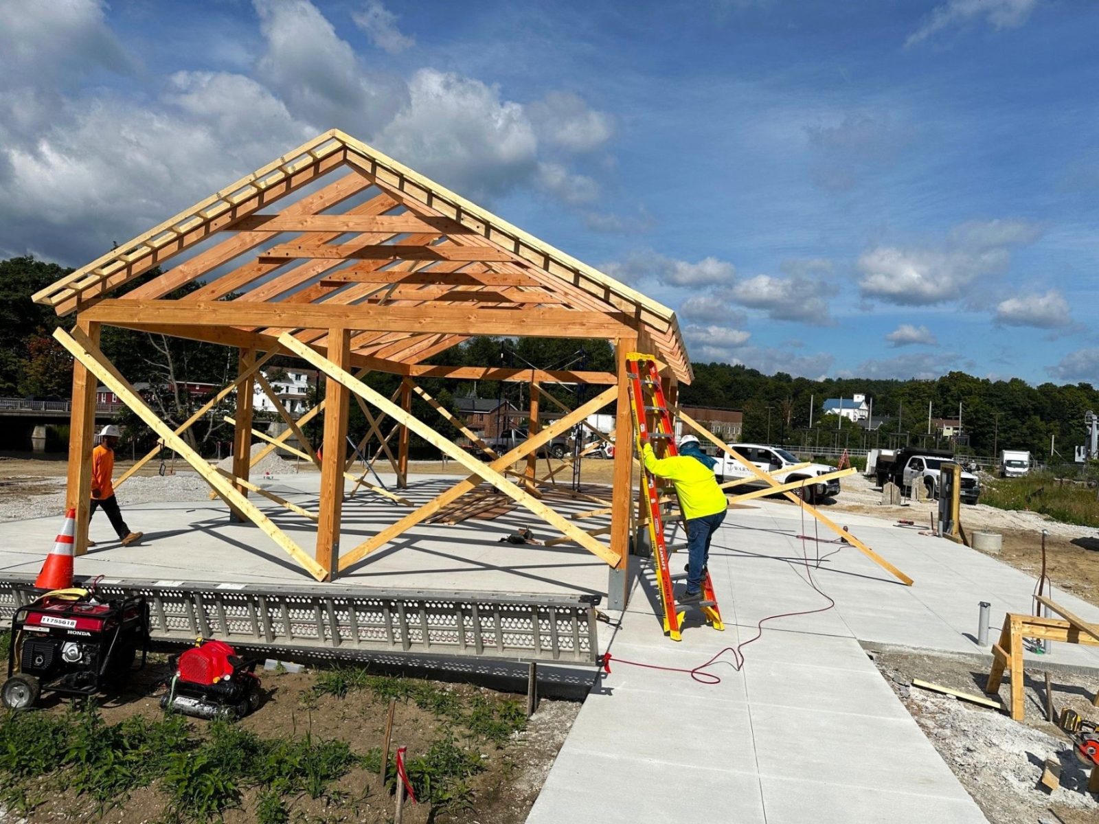 Construction workers are building a structure alongside the road, with tools and materials visible on the site.