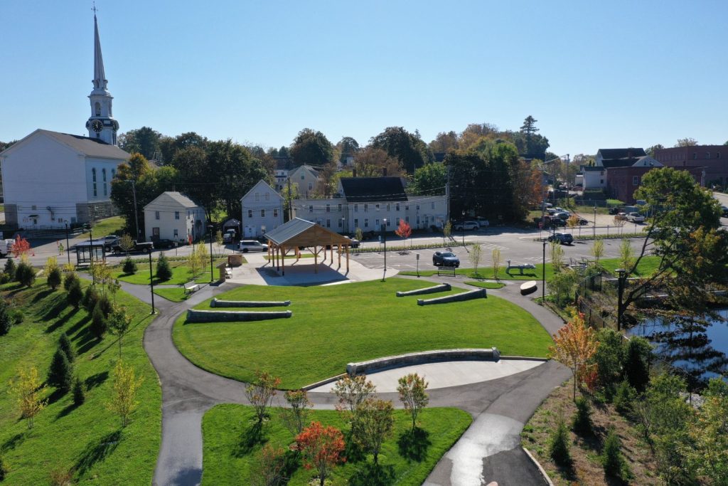 Overhead shot of a park with vibrant green grass and a church nestled among the greenery.