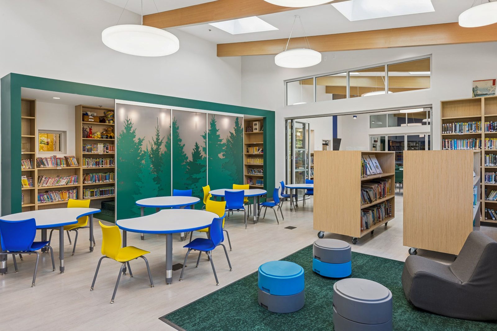 Rendering of interior classroom space with tables and yellow and blue chairs.