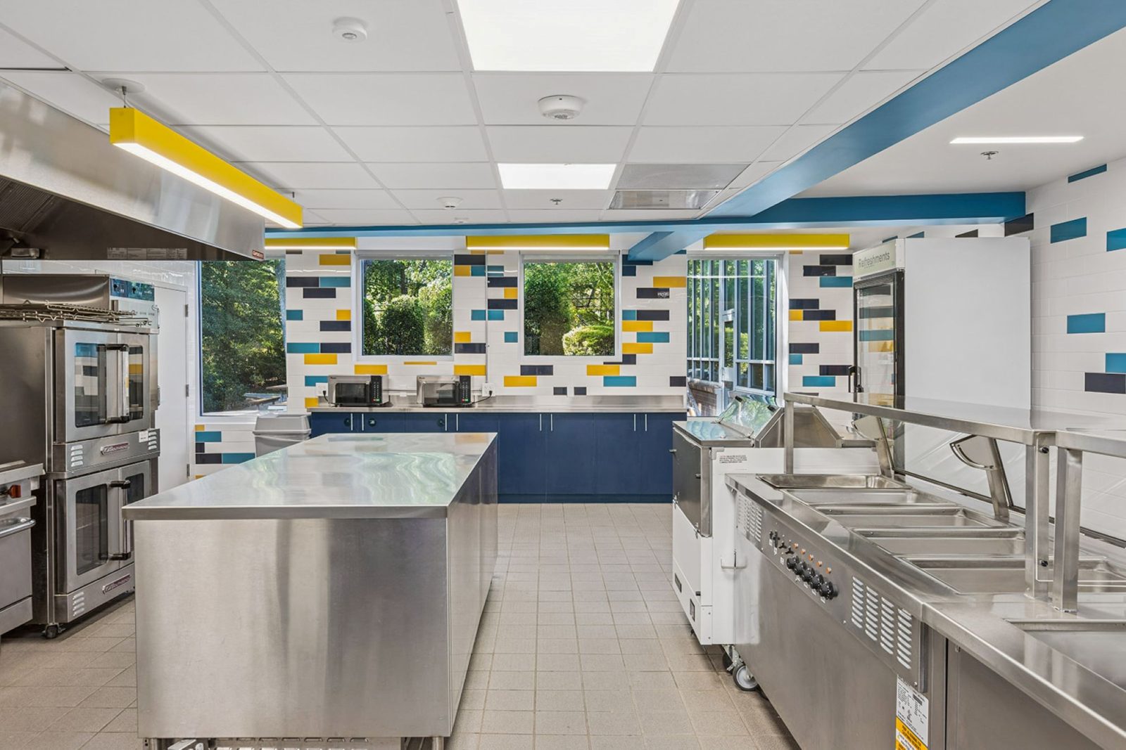 Interior commercial kitchen space with stainless steel appliances.